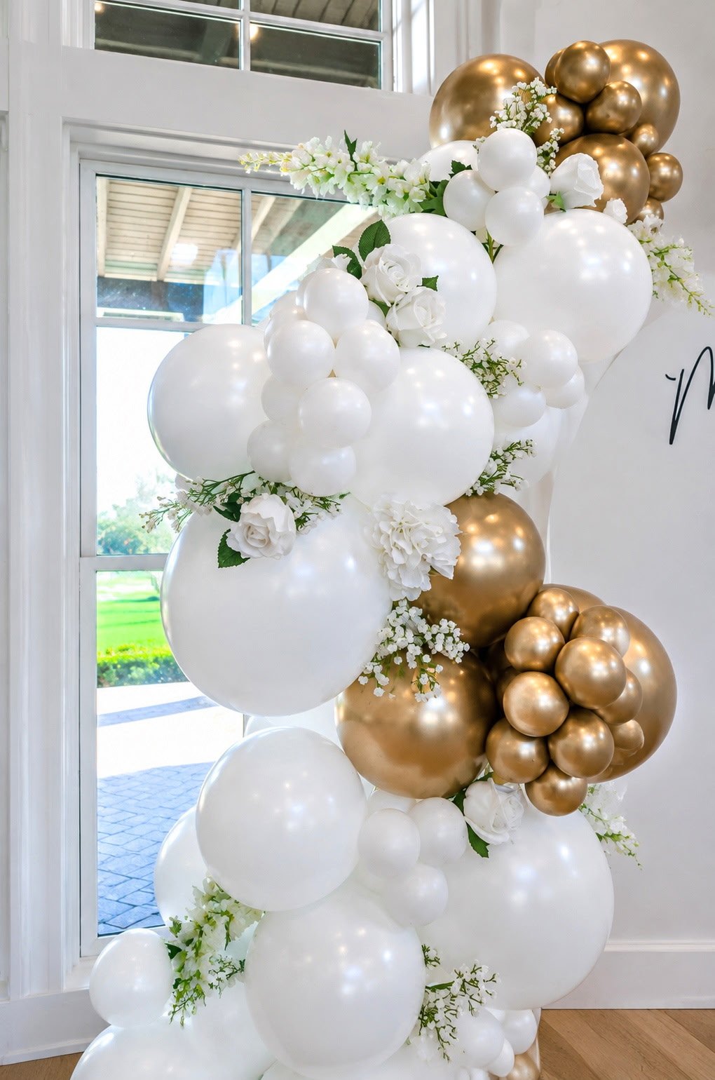 White and gold floral balloon garland installation